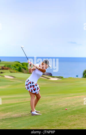 Jeune femme jouant au golf, Bali, Indonésie Banque D'Images