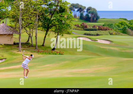 Jeune femme jouant au golf, Bali, Indonésie Banque D'Images