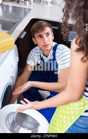 Réparateur professionnel près de lave-linge de female client Banque D'Images