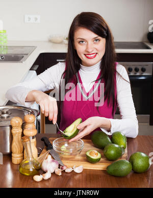 Jeune femme avec de l'avocat de cuisine cuisine à domicile Banque D'Images