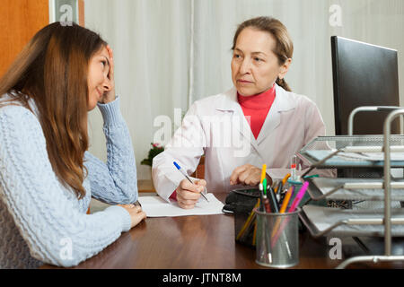 Femme médecin en uniforme avec jeune femme patient dans un centre Banque D'Images