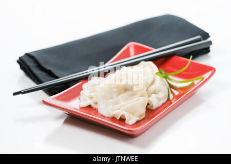 Plateau de légumes cuits à la vapeur raviolis chinois sur une plaque rouge. Banque D'Images