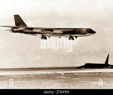 Un B-52 Stratofortress attend d'avion à côté de la piste comme un B-52G des approches pour l'atterrissage après avoir terminé une mission de bombardement sur le Nord du Vietnam au cours de l'opération LINEBACKER. Les avions sont du Commandement aérien stratégique. Banque D'Images