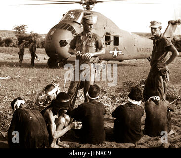 Une opération de Starlight, Corps des Marines des États-Unis search and destroy l'opération au sud de Chu Lai. Le nombre de victimes s'élevait à 599 Vc tué et six capturés. Le Viet Cong attendent les prisonniers en cours par hélicoptère à zone arrière. Août 1965. JUSPAO. (USIA) DATE EXACTE INCONNUE SHOT #  FICHIER NARA : 306-MVP-21-2 LIVRE Guerres et conflits #  : 415 Banque D'Images