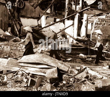 Trois vietnamiennes retournez dans la région de Cholon VC après un attentat qui a fait deux pâtés de maisons de niveau, dans l'espoir de sauver leurs maigres biens. Saigon, le 31 janvier 1968. USAIA (NARA) Dossier #  : 306-MVP-5-4 LIVRE Guerres et conflits #  : 421 Banque D'Images