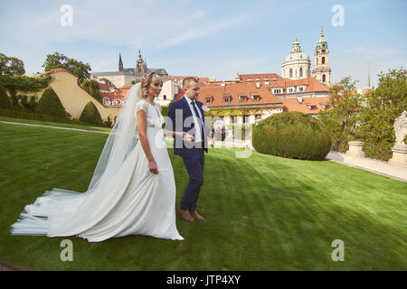 Les jeunes à pied autour de Prague. Ils voient les sites touristiques de la ville et sourire à des passants. Le soleil illumine le chemin pour un jeune couple. Banque D'Images