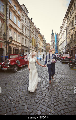 Les jeunes à pied autour de Prague. Ils voient les sites touristiques de la ville et sourire à des passants. Le soleil illumine le chemin pour un jeune couple. Banque D'Images