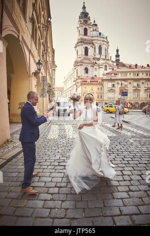 Les jeunes à pied autour de Prague. Ils voient les sites touristiques de la ville et sourire à des passants. Le soleil illumine le chemin pour un jeune couple. Banque D'Images