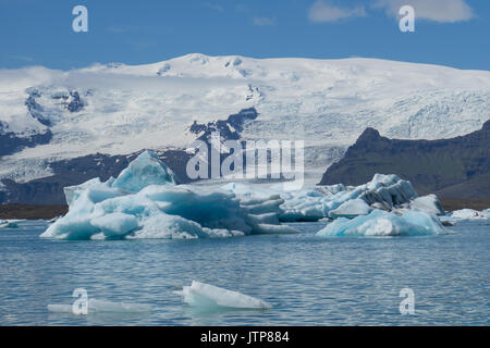 Islande - d'énormes icebergs brillant turquoise dans le lac glaciaire en face du glacier vatnajoekull massive Banque D'Images