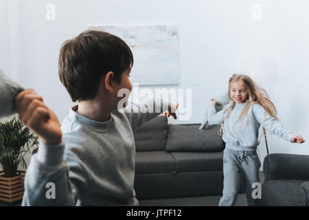 Petit garçon et fille jouant pillow fight à la maison Banque D'Images