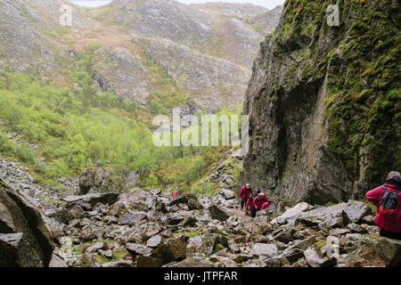 Les touristes à monter rocky path à Torghatten un trou dans une roche de granit sur la montagne de l'île dans l'archipel de Treana Torget Brønnøy Nordland en Norvège Banque D'Images