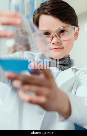 En d'écolier goggles holding flask en laboratoire chimique, science concept étudiant Banque D'Images