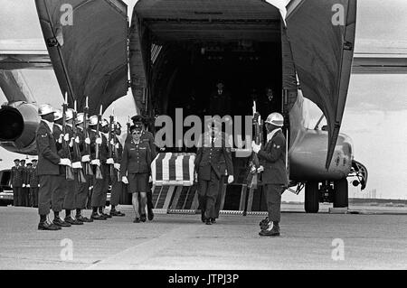 Une garde d'honneur de la Force aérienne est à l'attention tandis que la boîte de transfert d'un MIA du Nord Vietnam est retiré d'un avion C-141 Starlifter. Banque D'Images