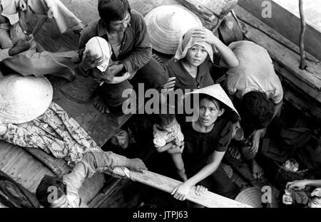 Réfugiés vietnamiens attendent d'être prises à bord du navire de commandement amphibie USS Blue Ridge (CAC 19). Le 35 refugeees ont été secourus par un bateau de pêche de 35 pieds à 350 milles au nord-est de la baie de Cam Ranh, au Vietnam, après avoir passé huit jours en mer. Banque D'Images