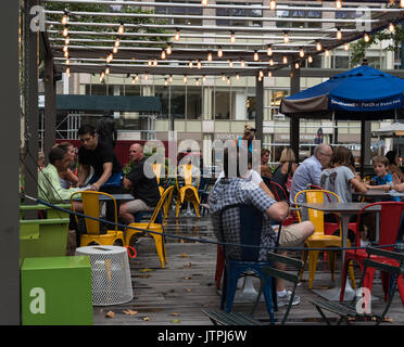 Les amis et les familles se rassemblent pour un en-cas et de conversation à la terrasse d'un café à Bryant Park, New York City. Usage éditorial uniquement. Banque D'Images