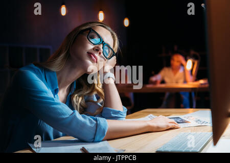 Épuisé young businesswoman in eyeglasses dormir au lieu de travail Banque D'Images