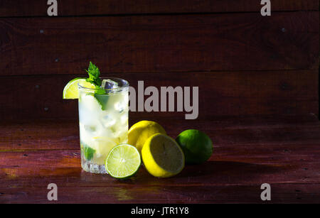 Un verre de limonade avec les tranches de citron, citron vert, menthe et glace Banque D'Images