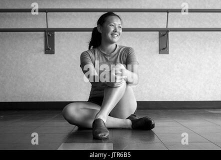 Version noir et blanc de danseuse jazz souriant dans la classe de jazz à l'écoute de son enseignement Banque D'Images