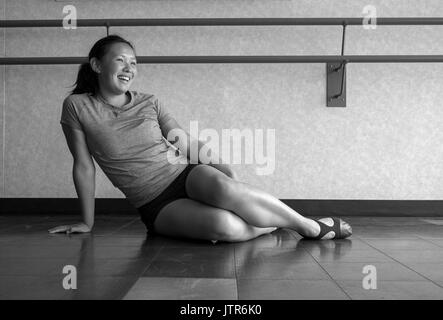 Version noir et blanc de danseuse Jazz portant des chaussures d'enseignement dans la classe de danse à l'écoute de son professeur Banque D'Images