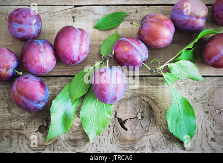 Les prunes violettes fraîches sur la table rustique en bois
