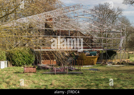 Un échafaudage recouvrant le feu des maisons endommagées, en rénovation Banque D'Images