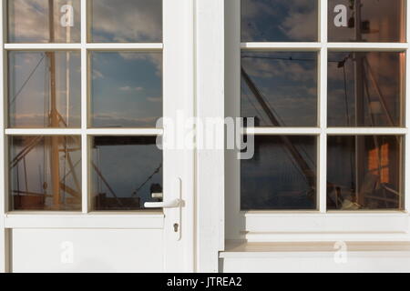 Les bateaux de pêche du port-blanc reflète dans la fenêtre d'une rorbuer-traditionnelles de pêche saisonnière chalet-maintenant pour des utilisations touristiques-côté ouest de la pêche à la p Banque D'Images