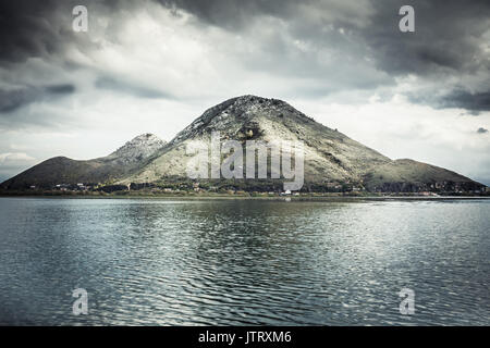 Paysage spectaculaire avec vue sur la montagne au littoral de l'île et avec de l'eau tranquille réflexion ciel couvert en journée avec moody sky Banque D'Images