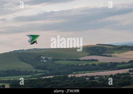 Firle Beacon, Lewes, East Sussex, UK..10 août 2017..un vent raide du Nord a attiré des pilotes de Hanglider à l'endroit de vol populaire dans les South Downs. À mesure que le vent a diminué en force Les pilotes De Parapente ont pris à l'air... Banque D'Images