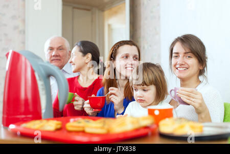 Heureux famille multigénérationnelle communiquer sur un plateau avec des gâteaux Banque D'Images
