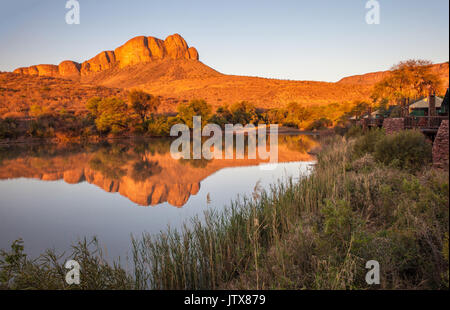 Tlopi tented camp surplombant le barrage avec les montagnes Waterberg reflète dans l'eau au coucher du soleil dans le parc national de Marakele, province du Limpopo Banque D'Images