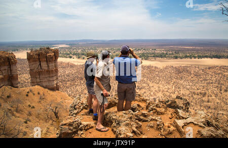 Trois touristes d'admirer la vue du haut de falaises Chilojo surplombant la rivière Runde pendant la saison sèche Banque D'Images