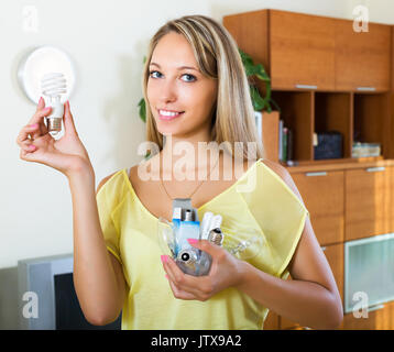 Smiling blonde girl holding ampoules à la maison Banque D'Images