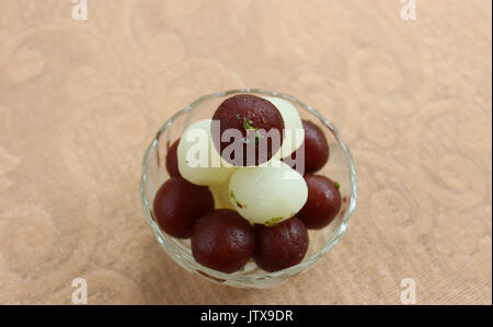 Jamun Gulab et Rasgulla couché sur l'autre dans un bol en verre Banque D'Images