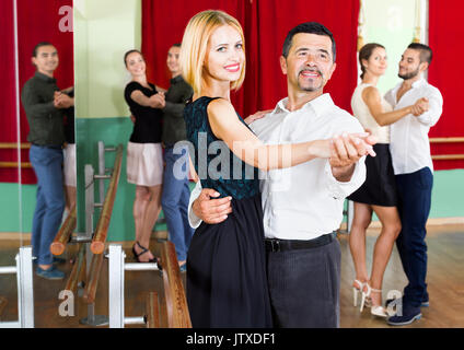 Happy smiling adultes ayant des danses graves dans la classe Banque D'Images