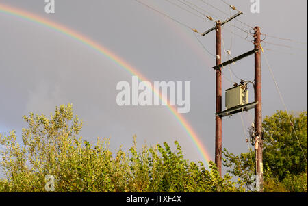 Double arc-en-ciel contre ciel gris au milieu des averses intermittentes. Banque D'Images