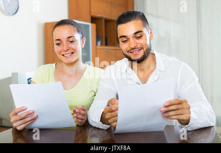 Young happy smiling couple avec documents à l'intérieur. L'accent sur guy Banque D'Images