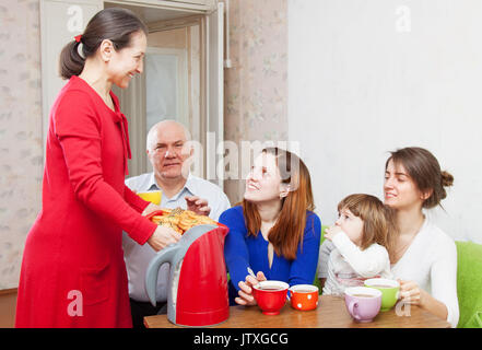 Famille multigénérationnelle communiquer sur un plateau avec des gâteaux Banque D'Images