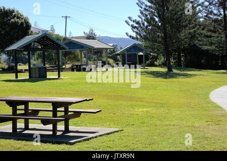 Le paysage du parc public en Australie. En vue de l'herbe verte, des arbres au sol, table en bois, banc en bois, cabanes de bois, poêles, gloriettes ombragées Banque D'Images