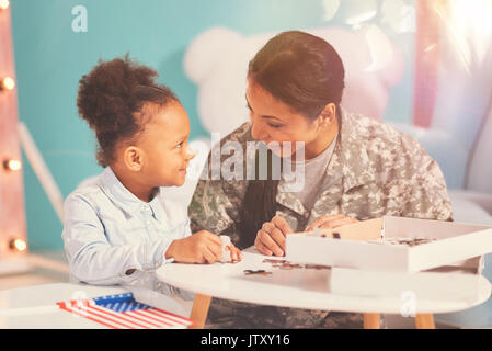 Mère militaire et sa fille faire un puzzle denteux Banque D'Images