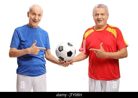 Deux joueurs de soccer âgés holding a football et de pointage isolé sur fond blanc Banque D'Images