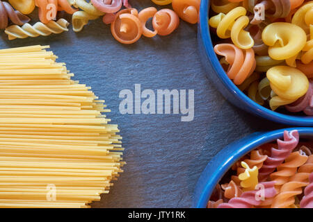 Des tas de pâtes dans des bols en céramique italienne et les spaghettis sur un fond sombre sur la Cuisine 24 Banque D'Images