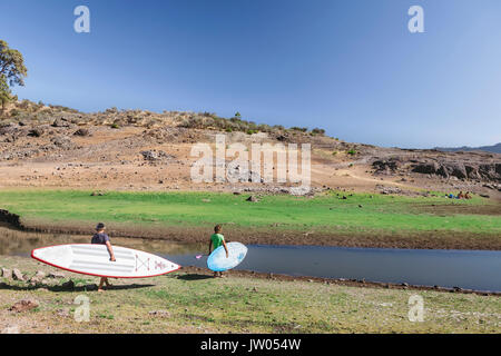 Deux stand up paddlers bénéficiant d'une session de stand up paddle le matin Banque D'Images