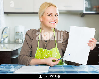 Jolie femme lisant un contrat pour le nouveau appartement et smiling Banque D'Images