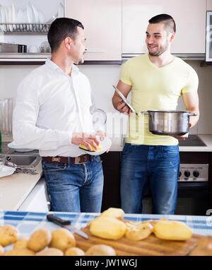 Les père et fils adultes soupe de pommes de terre de cuisson à l'intérieur. L'accent sur le bon homme Banque D'Images