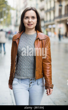 Smiling brunette girl with long hair chassant les rues de la ville Banque D'Images