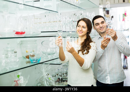 Famille jeune couple qui achète la verrerie en cuisine shop Banque D'Images