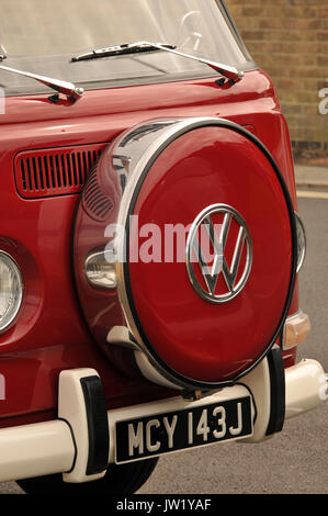 L'avant d'un original vw camper van peints en rouge avec un designer cache roue de rechange à l'avant. vintage air-cooled volkswagen cars restauré. Banque D'Images