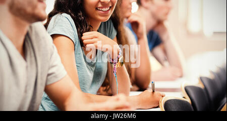 Smiling students à l'écoute de conférences en amphithéâtre Banque D'Images