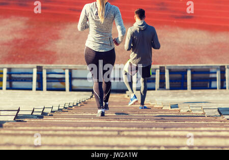 Close up of couple fonctionnant en bas sur stadium Banque D'Images