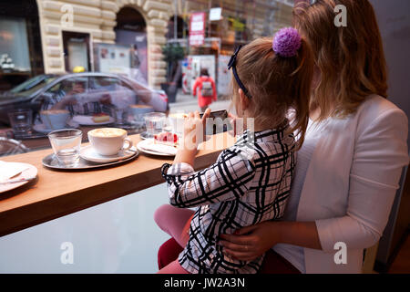 Jeune mère et fille passer du temps dans un café et faire des photos Banque D'Images